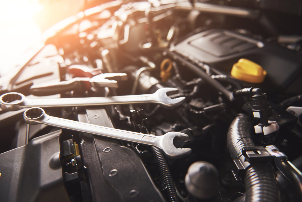 mechanic-hand-checking-and-fixing-a-broken-car-in-car-service-garage.jpg